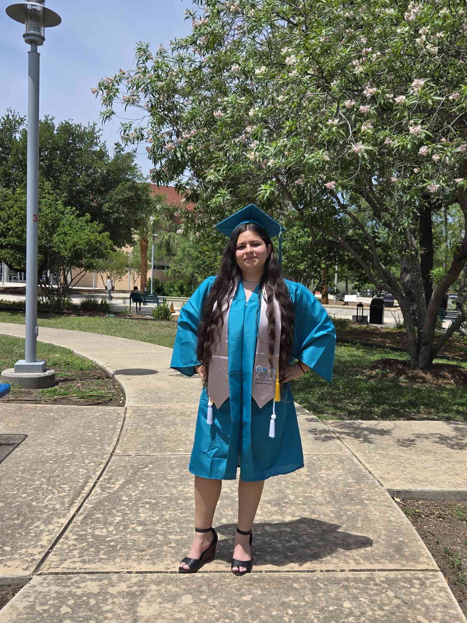 Guadalupe Del Cielo Flores Rios posing in her Palo Alto College Cap and Gown
